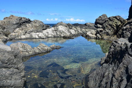 Stunning serene secret hidden natural pool among lava rocks in Aruba.