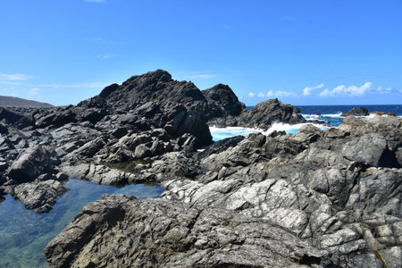 Shallow tidal pools forming among the lava rocks of the Aruban coast.