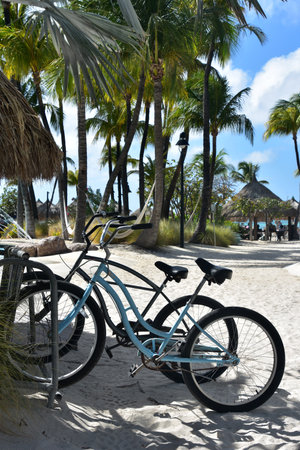 Pair of parked electric bikes on a beach in the sand.の写真素材