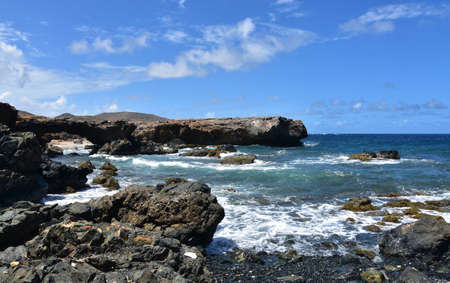 Black sand beach with rollicking seas along the rugged coast of Aruba.