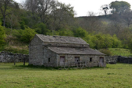 Historic old stone barn in a field in Northern England in the spring.の写真素材