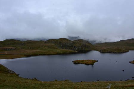 Thick fog at Angle Tarn on top of a fell in England.の写真素材