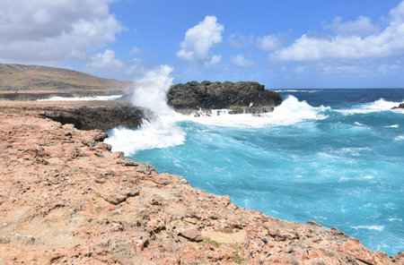 Large wave crashing against the rock bluffs in Aruba.の写真素材