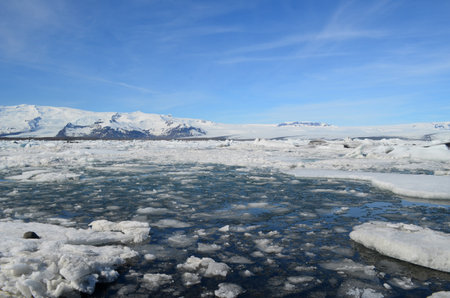 Beautiful scenic snow covered mountains and an icey lagoon in Iceland.