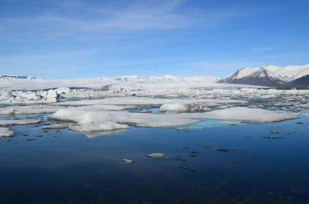 Beautiful blue lagoon with ice flow and snow covered mountains.