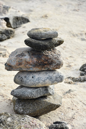 White sand beach with balancing tower of rocks.