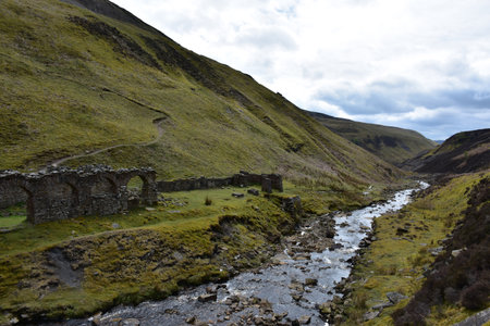Gunnerside stone archway ruins with a river running in England.の写真素材