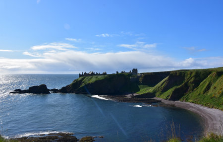 Sea cliffs with views of Dunnotar Castle off in the distance in Scotland.