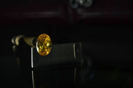 A beautiful yellow gem on a reflective glass floor.の写真素材