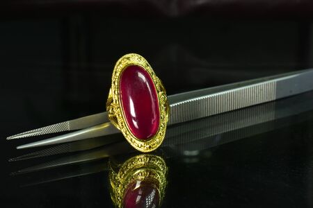 Gold ring Set with rubies, a beautiful red gemstone on the glass floorの写真素材