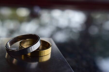 Two wedding rings Luxurious gold and silver On the wooden floorの写真素材
