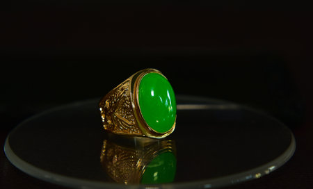 Gold ring Adorned with jade placed on the groundの写真素材