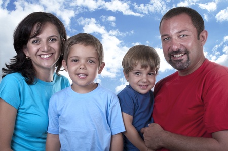 young family with two children on blue skyの写真素材