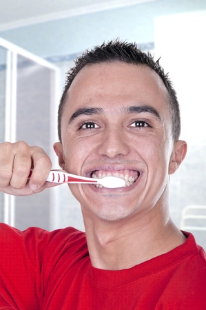 young man brushing his teeth in the bathroomの写真素材