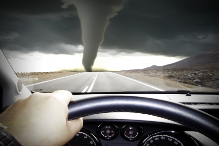 The car rushes on road towards to a tornadoの写真素材