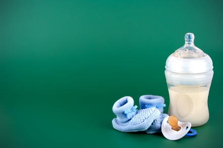 Baby items on green background