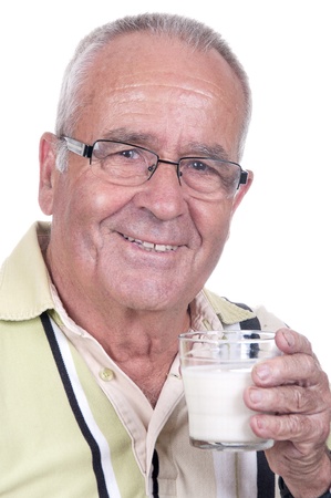 Senior holds happy a glass of milk in hand の写真素材