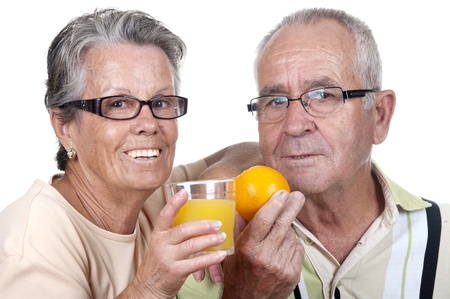 old couple holding an orange juice and  one orange, isolatedの写真素材