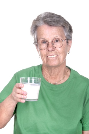 old woman holding a glass of milk on white backgroundの写真素材