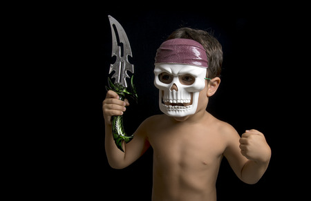 Little boy imitating a warrior with a sword and a maskの写真素材