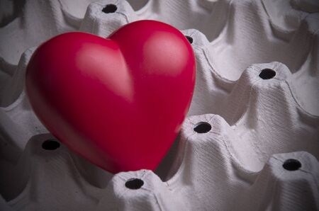 Red heart in paper carton for eggs.Fragility concept . (selective focus)の写真素材