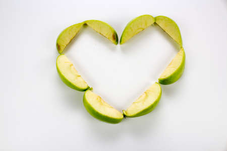 apple slices it forms a heartの写真素材