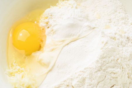 Making a pastry - flour and egg close-up.の写真素材