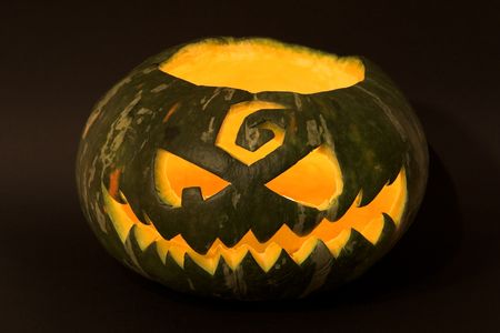 Jack-o'-lantern, spooky Halloween green pumpkin face.の写真素材