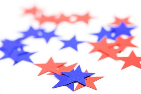 Red and blue tiny glitter Christmas stars on a white background, shallow dof.の写真素材