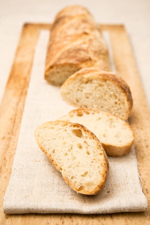 Homemade baguette, a French crusty long bread, with slices apart.の写真素材