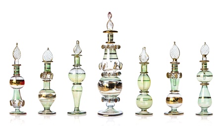 Row of green and golden oriental perfume bottles isolated on white.の写真素材
