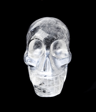 Traditional Central American quartz crystal carved skull, isolated on black.の写真素材