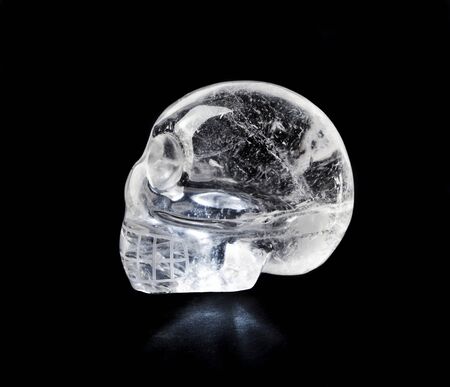 Traditional Central American quartz crystal carved skull, isolated on black.の写真素材