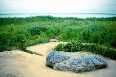 Blue rock over the lake on a cloudy day.の写真素材