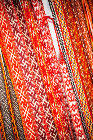 Vibrant handwoven textile braids w intricate geometric designs and traditional folk weaving patterns in various vivid colors. Eastern European culture, design inspiration, artistry of handmade craftsの写真素材