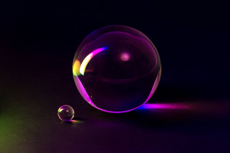 A captivating arrangement of glass spheres reflecting vibrant colorful lights, showcasing elegance...