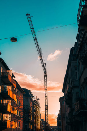 European city street bathed in warm sunset light, with a construction crane visible between...