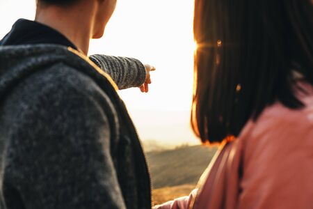 Young caucasian couple traveling and exploring new places while man is pointing with his finger where they must to go further.の写真素材