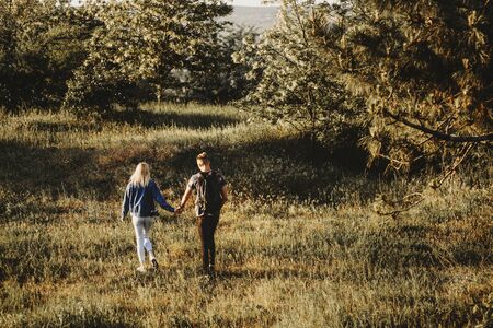 Full length portrait from back of lovely couple holding by hands and exploring new places while traveling.の写真素材