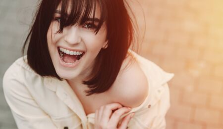 The upper view of a lovely brunette caucasian girl with nice smile being amazed of somethingの写真素材