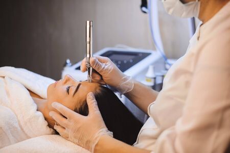 Brunette caucasian girl lying on the couch while having a spa procedure for her facial skin