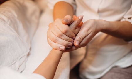 Caucasian masseur is massaging clients hand and prepare it for the next spa procedureの写真素材