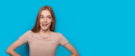 Caucasian woman with red hair and freckles is gesturing a tasty smell with her tongue while looking...