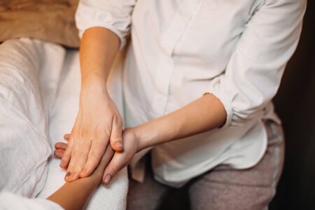 Upper view of a caucasian masseur having a hand massage session with the clientの写真素材