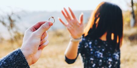Close up portrait of caucasian man showing a wedding ring to his womanの写真素材