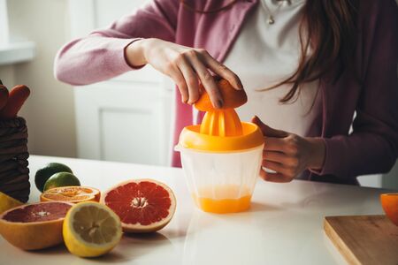 Close up photo of an orange juice squeezed with a squeezer by a caucasian woman with healthy habitsの写真素材