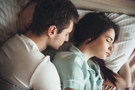 Lovely caucasian couple sleeping together in their bed embracing and resting
