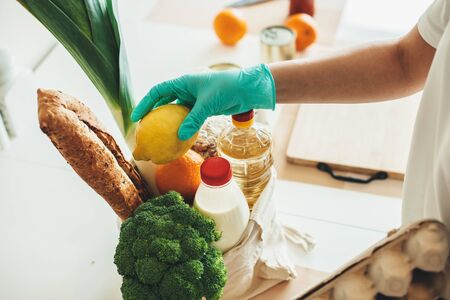 Caucasian person with gloves who got food through online delivery during the lockdownの写真素材