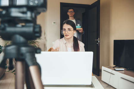 Brunette caucasian lady having an online lesson waiting for her husband to bring her the breakfastの写真素材