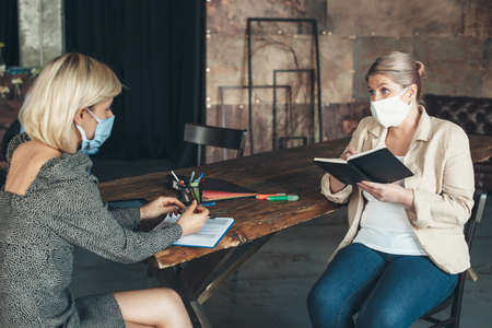 Caucasian businesswoman discussing during the quarantine about business and wear medical mask on...